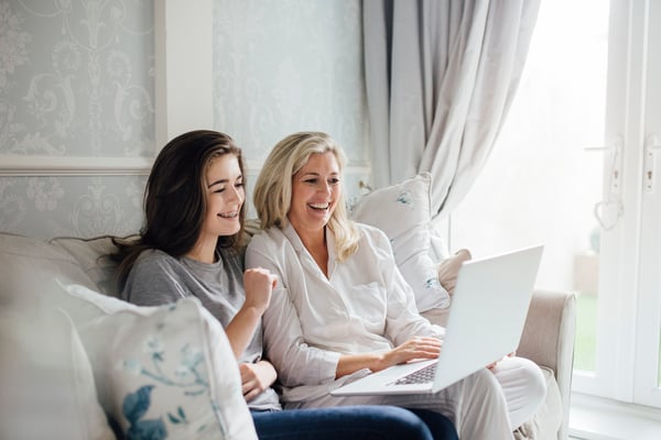 mother and daughter browsing laptop at home