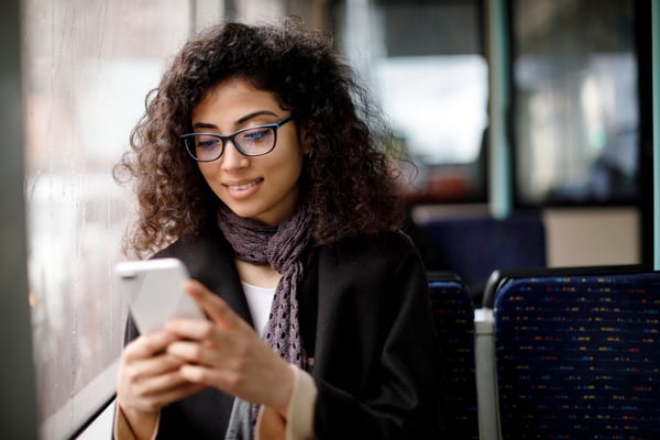 young woman browsing smartphone on train